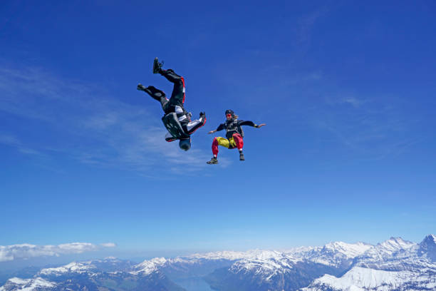 Freefall flier descend through lofty skies above mountain landscape Snow capped peaks below Grindlewald stock pictures, royalty-free photos & images