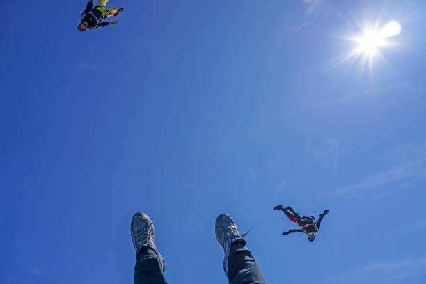 istock Freefall fliers descend through lofty skies above mountain landscape 1257601943