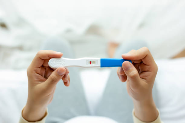 счастливая беременная женщина, держащая тест на беременность, изучить положительный тест, барышня имеет ребенка или плода в животе. молода� - pregnancy test стоковые фото и изображения