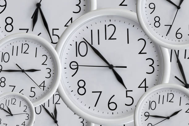 istock Background from set of white analog round office clocks of different sizes showing various time 1257602950