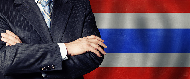 Male hands against Thai flag background, business, politics and education in Thailand concept