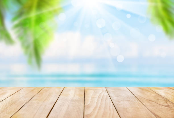 istock Wooden table top on blue sea and white sand beach. 1257607062