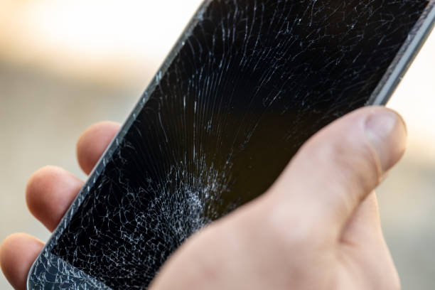istock A young man is holding a phone with a very cracked touch screen 1257608877