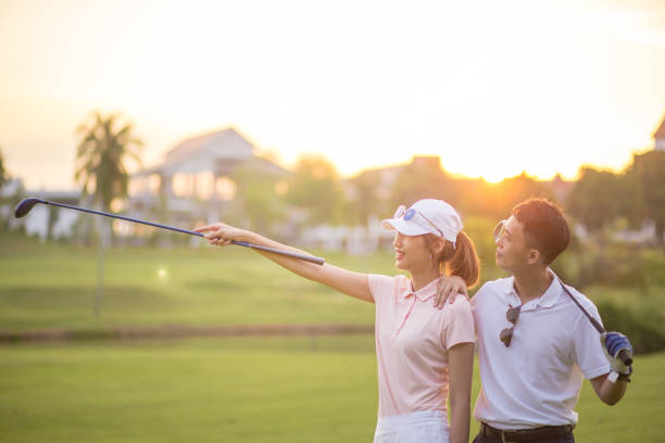 istock Two younger Chinese couple enjoying wonder sunset time during their golf course session. 1257609697