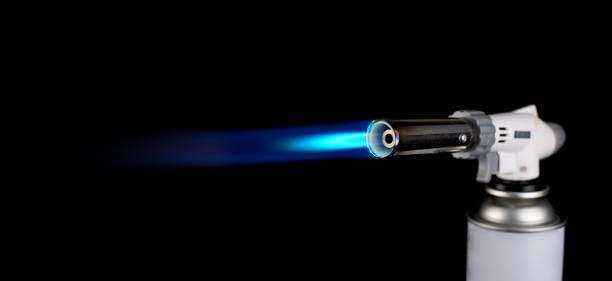 Gas burner with blue fire flame at black background Gas burner with fire flame at black background welding torch stock pictures, royalty-free photos & images