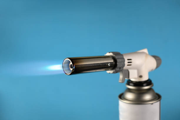 istock Gas burner with blue fire flame at blue background 1257610235
