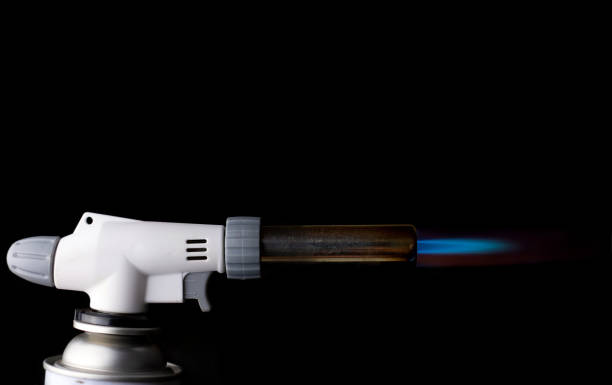 istock Gas burner with blue fire flame at black background 1257610241