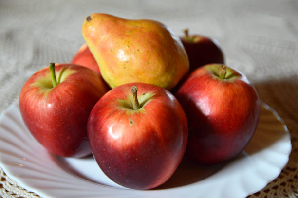 istock ripe pear and apples at the plate 1257610357