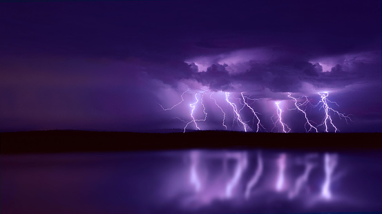 several lightning strikes during a strong thunderstorm over the lake.