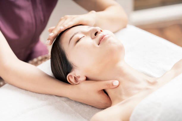 mujer joven teniendo su cabeza masajeada - health spa women spa treatment massager fotografías e imágenes de stock