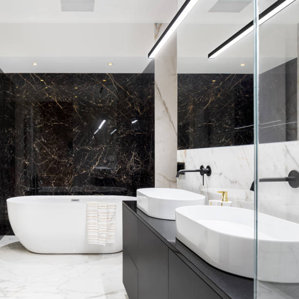 Elegant bathroom with black marble wall Elegant bathroom in black and white marble tiles on walls and floor, with big oval bathtub and two wash basins picture frame frame ellipse black stock pictures, royalty-free photos & images