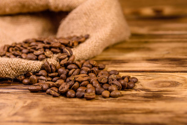 istock Sackcloth and scattered coffee beans on wooden table 1257616248