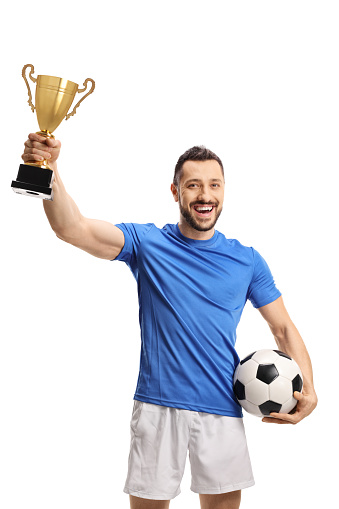 Soccer player holding a ball and a golden trophy cup isolated on white background