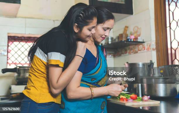 Indian Mother Is Teaching Her Daughter How To Chop Vegetable And Daughter Helping Mother In Kitchen Stock Photo - Download Image Now