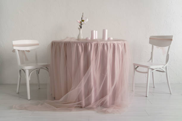 Two white chairs and covered table with pink clothes