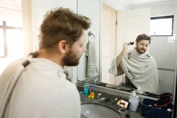 Man doing a self haircut at home.