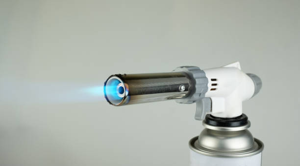 istock Flamethrower burner gas blow torch Ignition with blue fire flame at gray background 1257634454