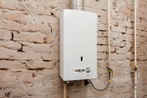 Closeup of gas water heater on a brick wall. Gas boiler in boiler room for hot water Closeup of gas water heater on a brick wall. Gas boiler in boiler room for hot water boiler stock pictures, royalty-free photos & images