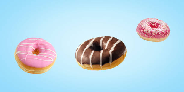 istock Different fresh donuts on blue background. Minimal food concept. 1257635067