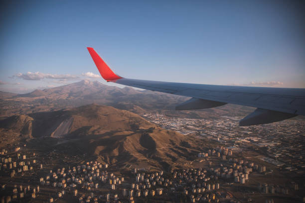 Airplane Wing in Flight view from airplane in flight on the Kayseri cityscape and Erciyes Mountain in Turkey stratosphere airplane cloudscape mountain stock pictures, royalty-free photos & images