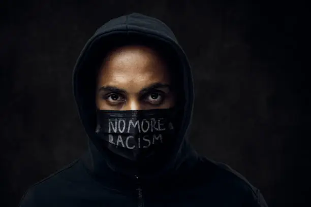 Afroamerican man wearing hoodie and black facial mask. Anti-racism concept.