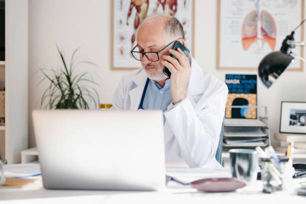 istock Mature doctor talking on the phone with patient 1257642665