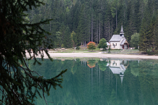 Chapel reflection in the morning at Pragser Wildsee (Lago di Braies) in the Dolomites, Italy