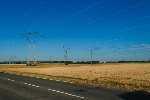 High voltage electricity pylons in the middle of the fields.