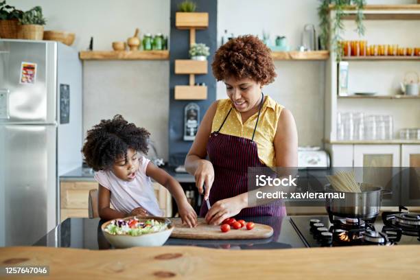 Afrocaribbean Mother And Young Daughter Cooking Together Stock Photo - Download Image Now