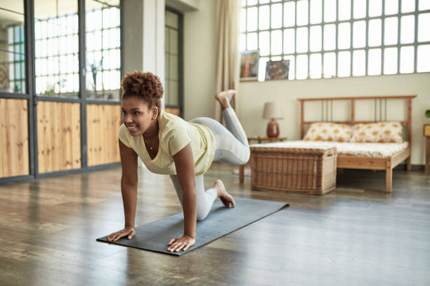 istock Woman in Mid 20s Stretching on Exercise Mat at Home 1257647447