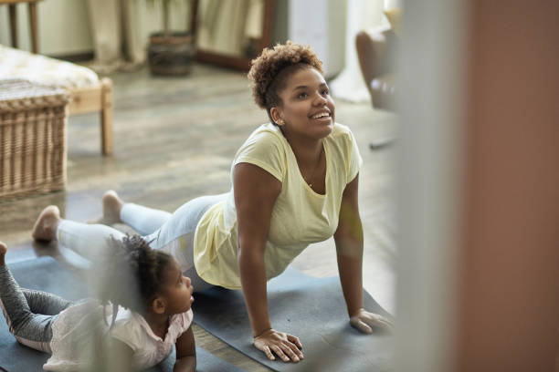 istock Young Daughter Learning Yoga-Style Exercises From Mother 1257647559