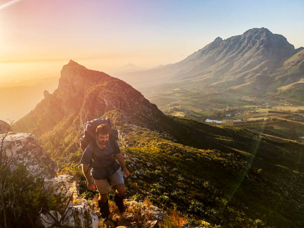 istock Man with a rucksack and beard Sunset Hiking in the Mountains 1257648824