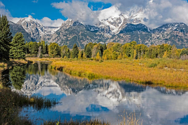 istock Water reflections of snow capped mountains and fall colors. 1257652237