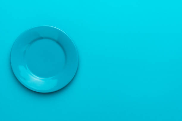 istock Top view of empty round blue plate on turquoise blue background with copy space 1257654616