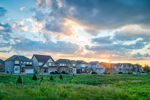 A row of new, detached houses in a residential district during sunset
