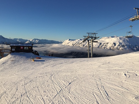 Blue sky and snow covered ski run at top of Alyeska Resort