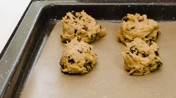 istock Chocolate Chip Cookies recipe. Placing cookie batter on a baking sheet, close up on white background, 1257661031