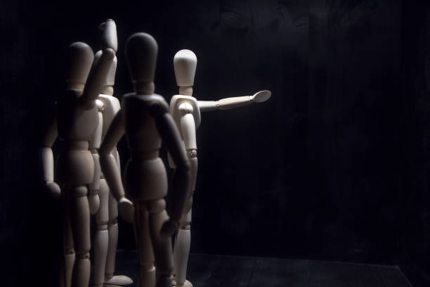 istock A drawing mannequin that points in a direction while other mannequins behind it look confused 1257661036
