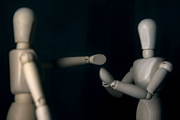 istock A drawing mannequin in the act of accusing while another one in front of it acts like it is praying to stop 1257661090