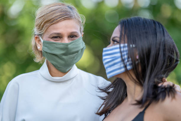 istock Mother and daughter wearing reusable protective face masks 1257661268