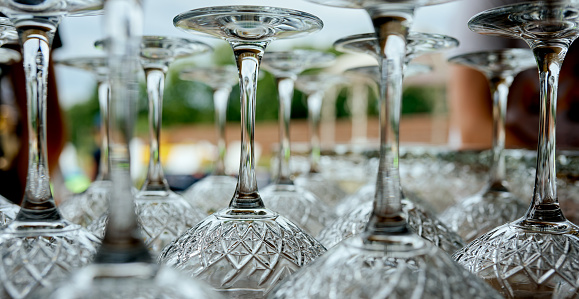 very close legs of wine glasses that stand upside down on the table . High quality photo