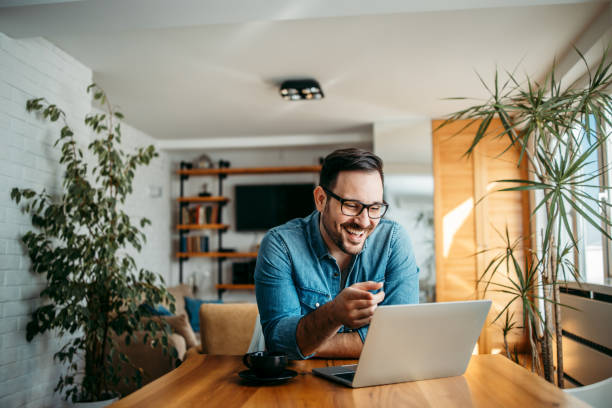 istock Portrait of a handsome man laughing while looking at laptop. 1257664212