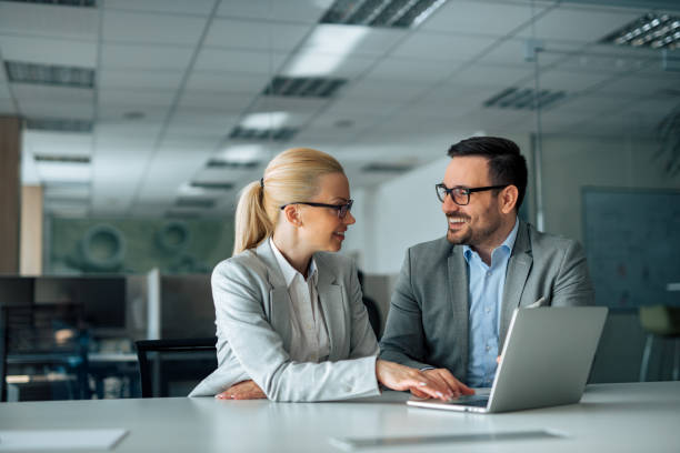 istock Work romance. Two business people looking at each other and smiling, portrait. 1257664312