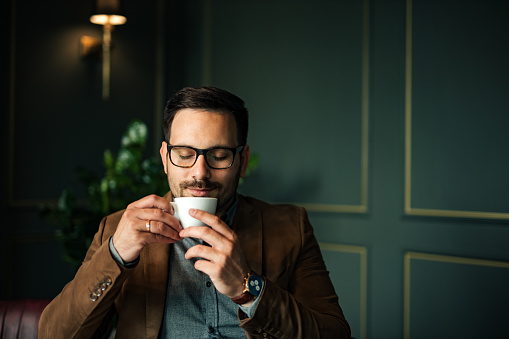 Hombre guapo disfrutando de una taza de café, retrato, primer plano. photo
