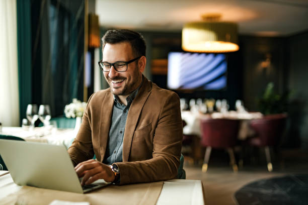 istock Happy man using laptop at restaurant, portrait. 1257664354