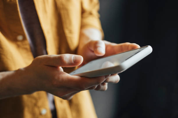 istock Anonymous Man Wearing a Yelow Shirt Using Modern Technology, a Close Up 1257664666