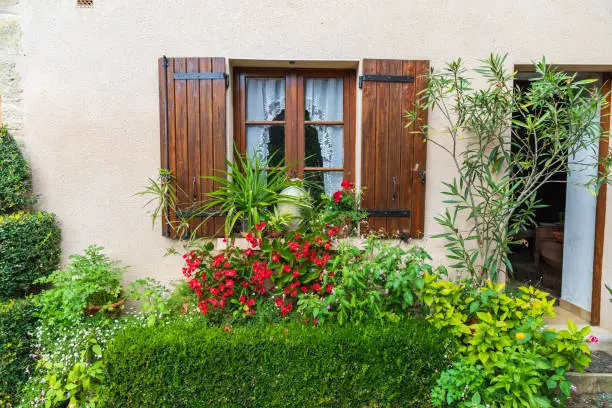 Europe, France, Dordogne, Hautefort. A brown shuttered window on a house in the town of Hautefort.