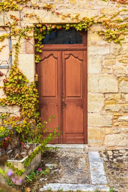 Europe, France, Dordogne, Hautefort. Brown door in a stone house in the town of Hautefort.