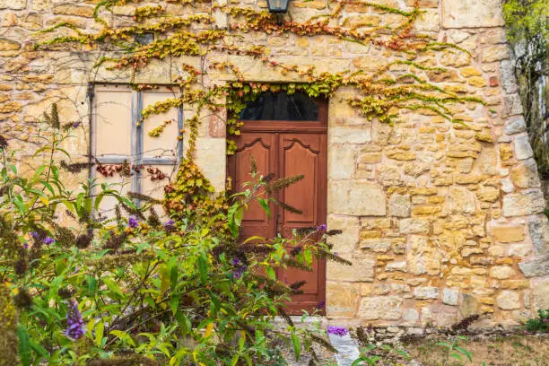 Europe, France, Dordogne, Hautefort. Brown door in a stone house in the town of Hautefort.