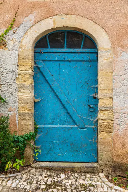 Europe, France, Dordogne, Hautefort. Old blue door on a building in the town of Hautefort.